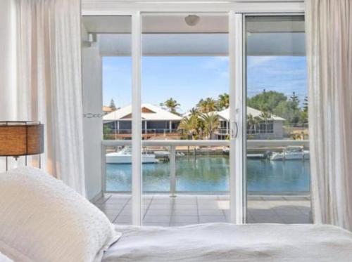 a bedroom with a large window with a view of the water at Port Sails Escape in Mandurah