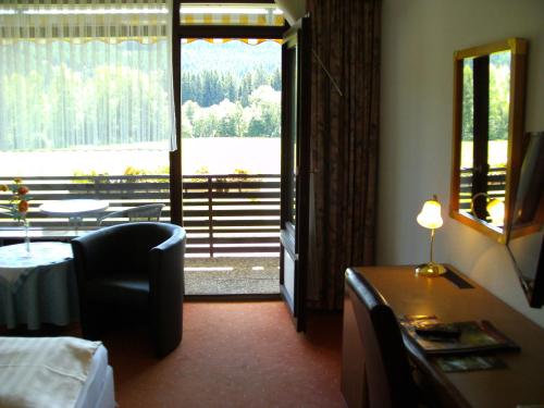 a hotel room with a bedroom with a view of a lake at Hotel Rheingold Garni in Titisee-Neustadt