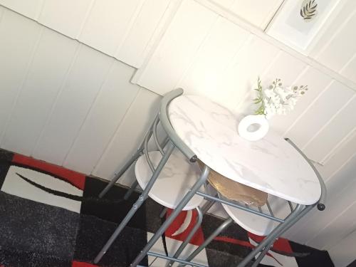 a white table with a vase of flowers on it at Guest house in Datteln in Datteln