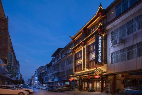 張家界市にあるHuayue Hongyuanju Boutique Art B&Bの車が建物の前に停まった街道