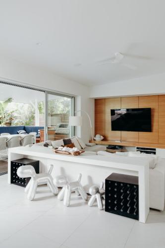 a white living room with a white table and chairs at Cavvanbah Lane in Byron Bay