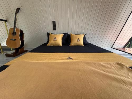 a bedroom with a bed with a guitar in it at Cabin Alpha in Bandarawela