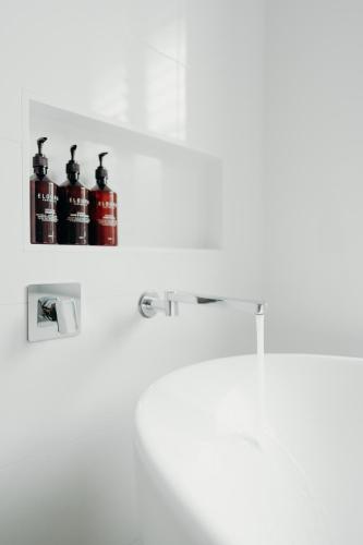 a shelf with two bottles of fire extinguishers on a wall at Cavvanbah Lane in Byron Bay