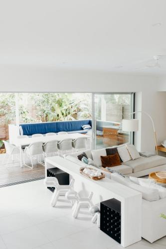 a living room with white furniture and a large window at Cavvanbah Lane in Byron Bay