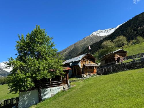 a log cabin in the mountains with a tree at Ipderi cottages in Lekhtagi