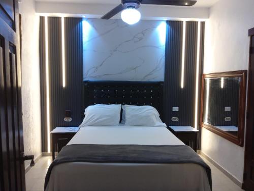 a bedroom with a large bed with a marble wall at Residence Tropical Garden in Boca Chica