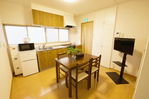 a small kitchen with a table and chairs in a room at 梅屋敷貸家 in Tokyo