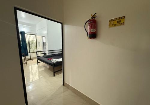a fire extinguisher sign on a wall next to a mirror at Buvana Lodge in Dudhnai