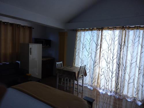 a bedroom with a window with a table and a chair at Residence Tropical Garden in Boca Chica