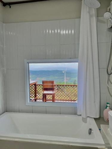 a bathroom with a tub and a window with a view at บ้าน มองดูหมอก in Ban Khok Hang Wang