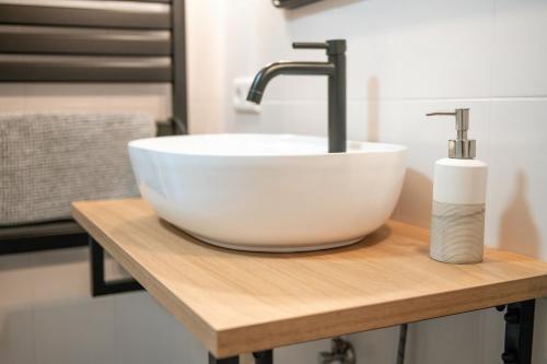 a white bowl sink on a wooden counter in a bathroom at Ferienwohnung Alpenglück in Seeg