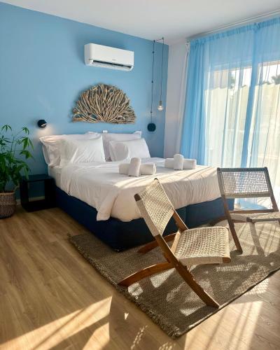 a bed with two chairs in a blue bedroom at Happy Village - Latchi in Polis Chrysochous