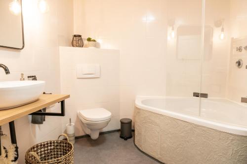 a bathroom with a tub and a toilet and a sink at Ferienwohnung Alpenglück in Seeg