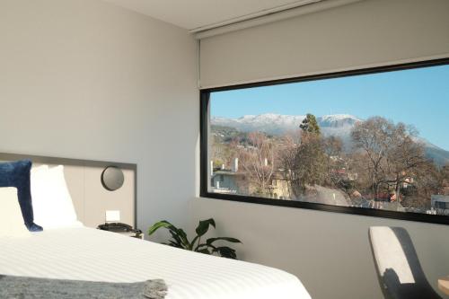 a bedroom with a large window with a mountain view at 429 Apartments & Suites in Hobart
