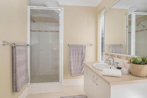 ein weißes Badezimmer mit Dusche und Waschbecken in der Unterkunft Ocean Pearls in Busselton