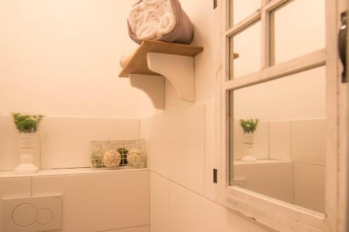 een badkamer met een raam en een plank met vazen bij Brigidahoeve in Maastricht