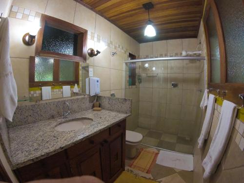 uma casa de banho com um lavatório e um chuveiro em Pousada Dom Angelo em Paraty