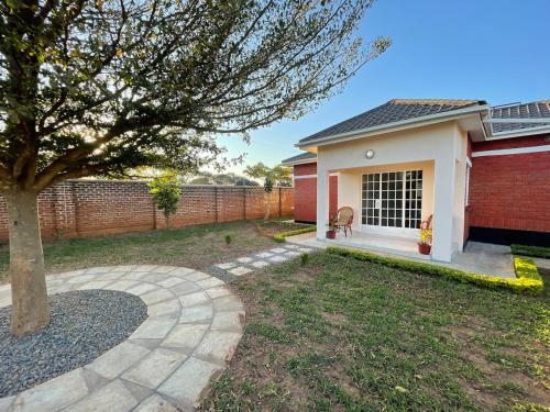 a house with a tree in the yard at Cozy home in Area 43, Lilongwe in Lilongwe