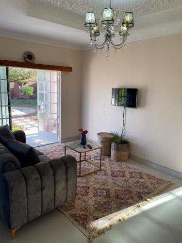 a living room with a couch and a chandelier at Cozy home in Area 43, Lilongwe in Lilongwe