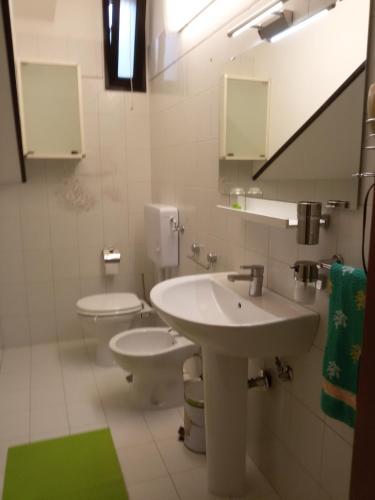a bathroom with two toilets and a sink and mirror at Corte Dei Messapi in Torchiarolo