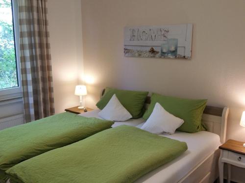 a bedroom with two beds with green sheets at Gästehaus Sonnenhügel in Möhnesee