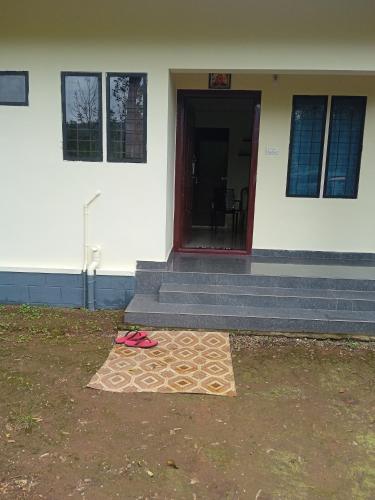 a house with a mat in front of a door at Homestay valakode in Idukki