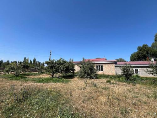 a house in the middle of a field at Adventure Guest House in Pokrovka