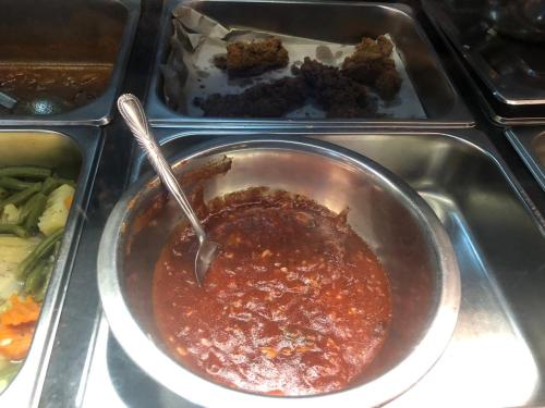 a pot of sauce in a tray with some food at e34 Café, Restaurant & Hotel Koslanda Hideaway with a Private Natural Pool in Koslanda