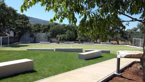 a park with benches on a grass field at Casa Das Oliveiras in Alvados