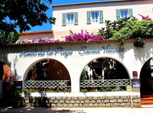 a building with flowers on the side of it at Hotel de la Plage Santa Vittoria in Algajola