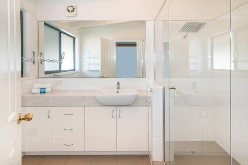 a white bathroom with a sink and a shower at Sea Breeze Villa in Dunsborough