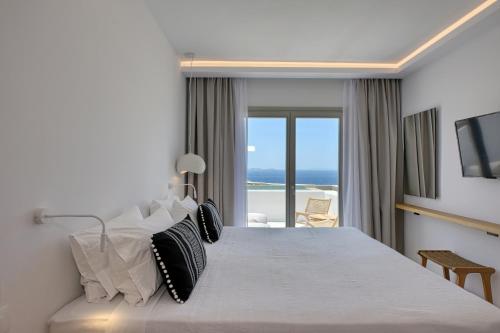 a bedroom with a bed with a view of the ocean at Paolas Sunset in Agios Stefanos