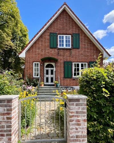 a red brick house with green shutters at Kleine Landhaus-Perle am Schlosspark in Eutin