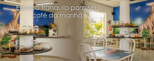 a restaurant with giraffes painted on the wall at Hotel Pousada Do Leão in Lençóis Paulista