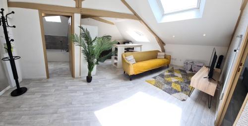 a living room with a yellow couch and a tv at Appartement 2 chambres in Charleville-Mézières