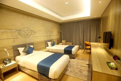 a hotel room with two beds and a television at SSK Urmee in Cox's Bazar