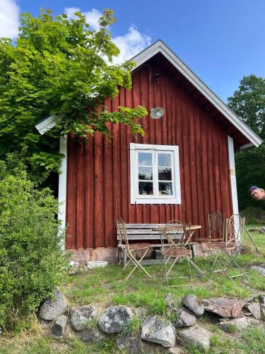 a red house with a table and chairs in front of it at Barnebo 3-6 in Blomstermåla