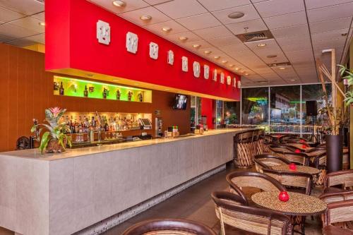 a restaurant with a bar with tables and chairs at El Tropicano Riverwalk in San Antonio