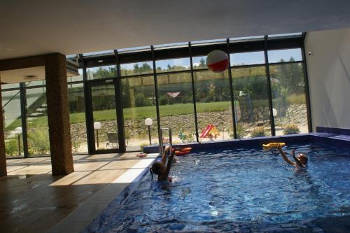 three people playing with a ball in a swimming pool at Pensjonat Łysica Wellness & Spa in Święta Katarzyna