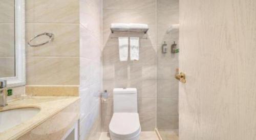 a bathroom with a toilet and a sink and a tub at Vienna Hotel Guiyang Jiaxiulou Jichang Road in Guiyang