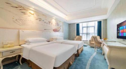 a hotel room with four beds and a television at Vienna Hotel Guiyang Jiaxiulou Jichang Road in Guiyang