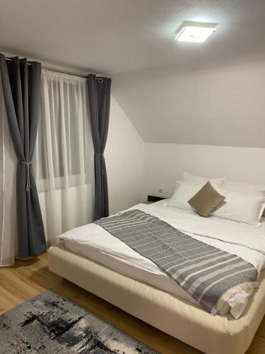 a bedroom with a large bed with black curtains at Casa Valex in Tohanu Nou