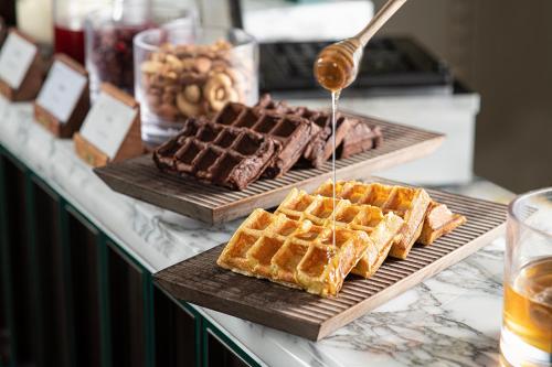 Un buffet con gofres y chocolate en una mesa. en Hangzhou Wulin GDA Hotel, Vignette Collection, en Hangzhou