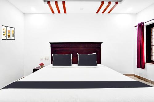 a bedroom with a large bed with black and white sheets at Hotel O Ernakulam Near North Railway Station in Cochin