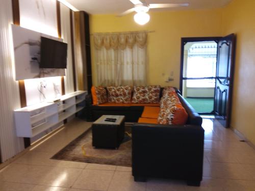 a living room with a couch and a tv at Residence Tropical Garden in Boca Chica