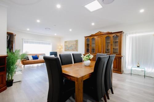 a dining room with a wooden table and black chairs at Disability Friendly 4 Bedroom House with 3 Baths Perfect for All Guests in Fairfield