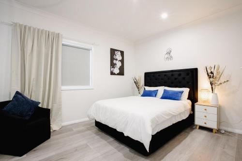 a bedroom with a bed with blue pillows and a window at Disability Friendly 4 Bedroom House with 3 Baths Perfect for All Guests in Fairfield
