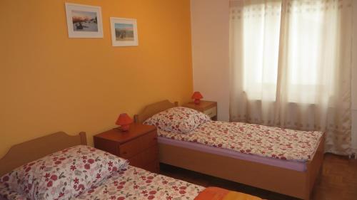 a bedroom with two twin beds and a window at Hisa Lescer in Kobarid