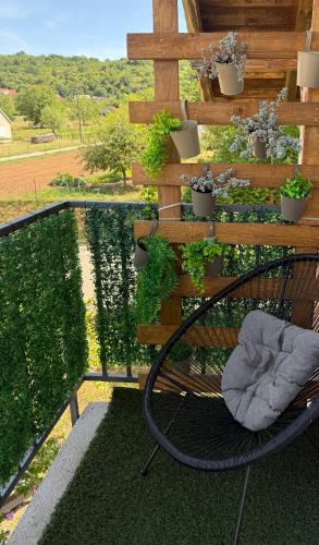 a bench sitting on a balcony with potted plants at Stellar Otavice in Otavice