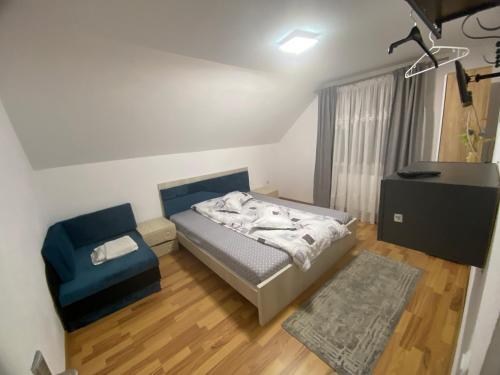 a small bedroom with a bed and a chair at Casa Valex in Tohanu Nou